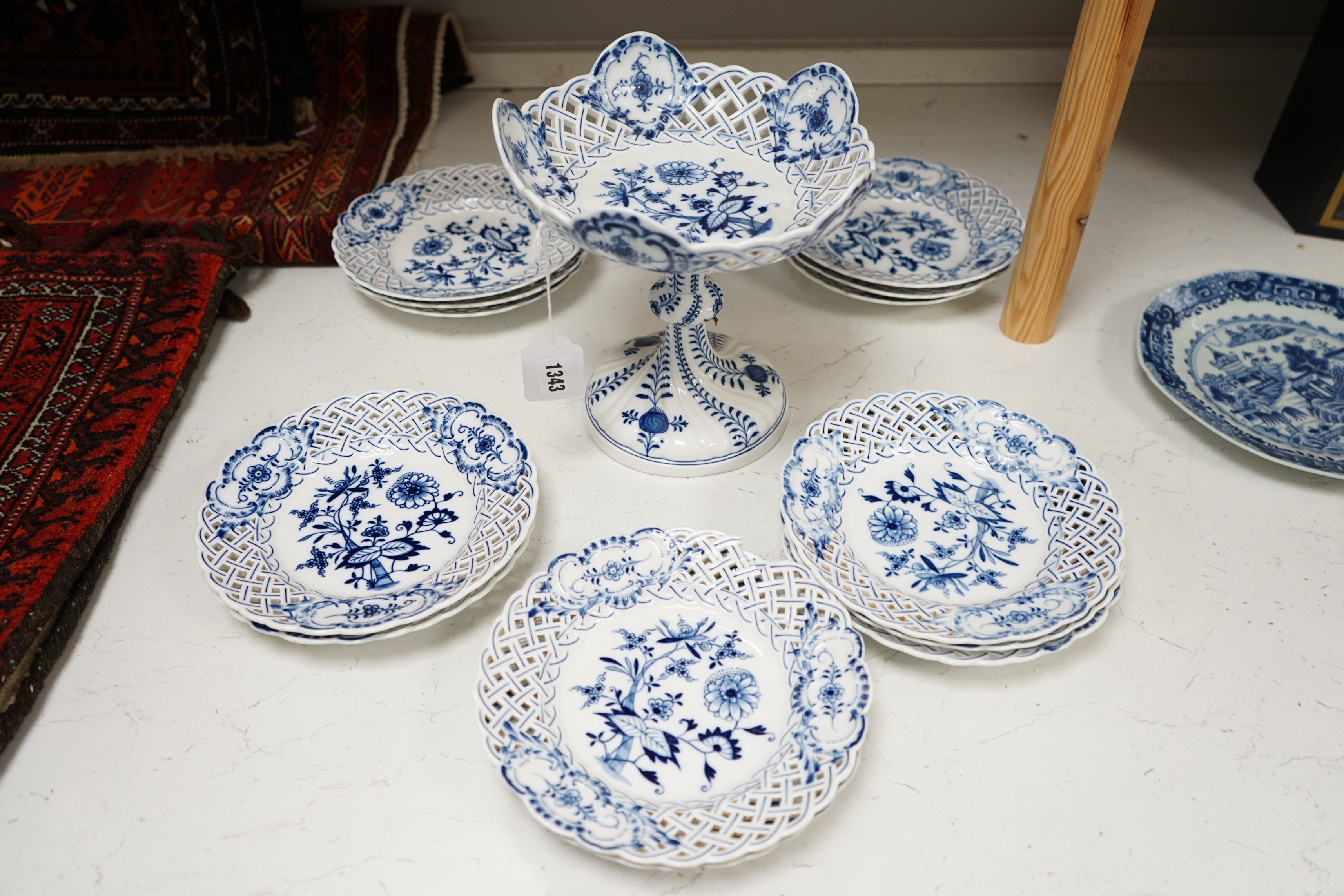 A late 19th Meissen blue and white onion pattern dessert service, consisting of a pair of comports and twelve dishes, all with pierced borders, (14). Condition - poor to good, two plates with pieces of border missing, on